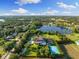 Estate featuring an expansive lawn, private lake access, tennis court and meticulously landscaped grounds at 18521 Wayne Rd, Odessa, FL 33556