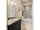 Elegant bathroom features a granite countertop, dark wood cabinets, a toilet, and a tiled shower with a curtained tub at 18521 Wayne Rd, Odessa, FL 33556