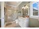 Bathroom with a walk-in shower, decorative light fixture and large mirror at 18521 Wayne Rd, Odessa, FL 33556
