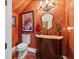 Stylish half-bath with vibrant orange walls and custom vanity at 18521 Wayne Rd, Odessa, FL 33556