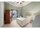 This quaint bedroom is painted a light green, with white trim, beige carpet, a full-size bed, and an armoire at 18521 Wayne Rd, Odessa, FL 33556