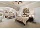 An open bedroom with fireplace, sitting area, a tray ceiling, ensuite with vanity, and large windows with natural light at 18521 Wayne Rd, Odessa, FL 33556