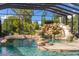 This unique pool includes a stone bridge, waterfall, slide, and mature tropical landscaping, offering an oasis for summer fun at 18521 Wayne Rd, Odessa, FL 33556