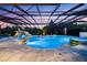 The screened pool area is enhanced by illuminated waterfalls, a spa, and lush tropical landscaping at 18521 Wayne Rd, Odessa, FL 33556