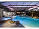 The glowing custom pool and spa, with waterfall and slide, are protected by a screened enclosure at 18521 Wayne Rd, Odessa, FL 33556