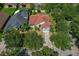 An aerial view shows a single-Gathering house with a red roof, set among mature trees and landscaping in a quiet neighborhood at 19206 Ivy Oak Way, Tampa, FL 33647