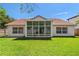 Expansive backyard with well-maintained lawn and large glass windows for sunroom at 19206 Ivy Oak Way, Tampa, FL 33647