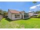 Back exterior of home features a sunroom with large windows and a well manicured backyard lawn at 19206 Ivy Oak Way, Tampa, FL 33647