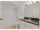 Bathroom with white tiled shower and white vanity with a brown marble countertop at 19206 Ivy Oak Way, Tampa, FL 33647