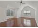 Bright bedroom boasts hardwood floors, a ceiling fan, and lots of natural light from the large, arched windows at 19206 Ivy Oak Way, Tampa, FL 33647