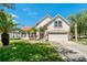 Charming two-story home featuring a lush, green lawn and beautiful palm trees at 19206 Ivy Oak Way, Tampa, FL 33647