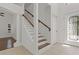 Bright foyer features a staircase, decorative glass front door, and tile flooring at 19206 Ivy Oak Way, Tampa, FL 33647