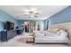 A large bedroom with walk-in closets, blue walls, and a ceiling fan at 2073 Branding Iron Way, New Port Richey, FL 34655