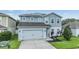 Beautiful two-story home featuring a two-car garage, solar panels, and a well-manicured lawn at 2073 Branding Iron Way, New Port Richey, FL 34655