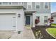 Charming two-story home with a blue front door, beautiful landscaping, and a welcoming walkway at 2073 Branding Iron Way, New Port Richey, FL 34655