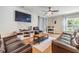 Spacious living room with comfortable leather seating, ceiling fan, and large windows for natural light at 2073 Branding Iron Way, New Port Richey, FL 34655