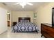 Comfortable bedroom showcasing a bed with a patterned comforter and a dresser, plus a view into an adjoining bathroom at 22442 Vale Ave, Punta Gorda, FL 33980