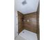 Walk-in shower with sleek, modern wood-look tiling and a built-in niche for toiletries, ensuring a stylish space at 22442 Vale Ave, Punta Gorda, FL 33980
