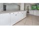Kitchen island featuring tile floors, granite countertops, and white cabinets with black knobs at 2532 Sweetgum W Way, Clearwater, FL 33761