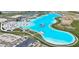 Stunning aerial view of the community lagoon featuring white sand beaches, a water park and beautiful turquoise water at 31105 Mango Fade Way, San Antonio, FL 33576
