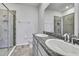 Bathroom featuring double sinks with granite countertops and tiled walk-in shower at 31105 Mango Fade Way, San Antonio, FL 33576
