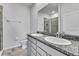 Bathroom featuring double sinks with granite countertops and tiled walk-in shower at 31105 Mango Fade Way, San Antonio, FL 33576