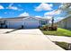 View of a single-story home with a wide driveway, and three-car garage under a blue sky at 31105 Mango Fade Way, San Antonio, FL 33576