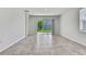 A bright living room with neutral tile floors, white walls, and a sliding glass door to the yard at 31105 Mango Fade Way, San Antonio, FL 33576