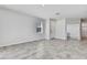A spacious living room with neutral tile floors, white walls, a window and a hallway entrance at 31105 Mango Fade Way, San Antonio, FL 33576