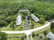An aerial view of condominiums with plenty of parking surrounded by a lush forest at 3232 Lake Pine E Way # A2, Tarpon Springs, FL 34688