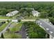 An aerial view of residential buildings with reserved parking and lush, green trees surrounding the community at 3232 Lake Pine E Way # A2, Tarpon Springs, FL 34688