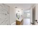 Modern bathroom with marble shower, wood vanity, and a view into the bedroom at 3232 Lake Pine E Way # A2, Tarpon Springs, FL 34688