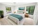 Staged bedroom features light wood floors, a comfortable bed, and two large windows at 3232 Lake Pine E Way # A2, Tarpon Springs, FL 34688