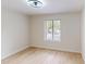 Vacant bedroom offers wood-look flooring, a ceiling fan and a large window at 3232 Lake Pine E Way # A2, Tarpon Springs, FL 34688