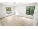 This bedroom has light wood floors and two windows offering a view of the outdoors at 3232 Lake Pine E Way # A2, Tarpon Springs, FL 34688