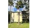 Charming condo building featuring a well-manicured lawn and tall palm trees at 3232 Lake Pine E Way # A2, Tarpon Springs, FL 34688