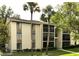 Condo exterior showcasing the multiple levels, palm trees, and landscaping at 3232 Lake Pine E Way # A2, Tarpon Springs, FL 34688