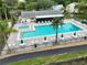 A refreshing community pool and jacuzzi are surrounded by lounge chairs and tables with umbrellas at 3232 Lake Pine E Way # A2, Tarpon Springs, FL 34688