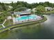 A swimming pool and jacuzzi are located near a pond on the community property at 3232 Lake Pine E Way # A2, Tarpon Springs, FL 34688