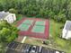 A close aerial view of two tennis courts with parking and condo buildings visible at 3232 Lake Pine E Way # A2, Tarpon Springs, FL 34688