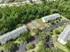 This aerial view captures the tennis courts nestled between two condo buildings and parking at 3232 Lake Pine E Way # A2, Tarpon Springs, FL 34688