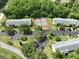 An aerial view of the community tennis courts and condo buildings with reserved parking at 3232 Lake Pine E Way # A2, Tarpon Springs, FL 34688