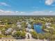 Aerial view of a neighborhood with a small lake with a fountain surrounded by many trees and homes at 3301 Haviland Ct # 301, Palm Harbor, FL 34684
