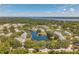 Aerial view of the community featuring a lake, swimming pool, clubhouse and lush green landscaping at 3301 Haviland Ct # 301, Palm Harbor, FL 34684
