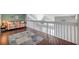 Open loft features hardwood floors, a colorful daybed and a stairway with white wooden bannister at 3301 Haviland Ct # 301, Palm Harbor, FL 34684