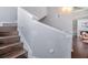 Wooden staircase ascending with white railings and neutral colored walls at 3301 Haviland Ct # 301, Palm Harbor, FL 34684
