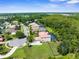 Expansive aerial view of a suburban home with a large yard, screened pool, and lush green surroundings at 3500 Ballastone Dr, Land O Lakes, FL 34638