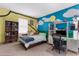 Whimsical bedroom featuring a fun mural, shelving, and a comfortable bed with a study space at 3500 Ballastone Dr, Land O Lakes, FL 34638
