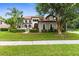 Inviting two-story home showcasing a tile roof, arched entry, and well-maintained front yard at 3500 Ballastone Dr, Land O Lakes, FL 34638