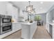 Bright kitchen featuring white cabinets, stainless steel appliances, and a large center island at 3500 Ballastone Dr, Land O Lakes, FL 34638